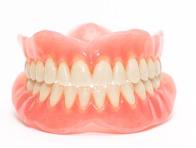 Full set of dentures on white background