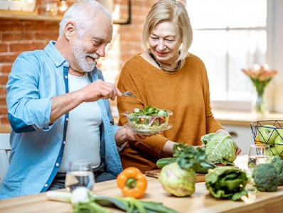 Couple in their kitchen making salad