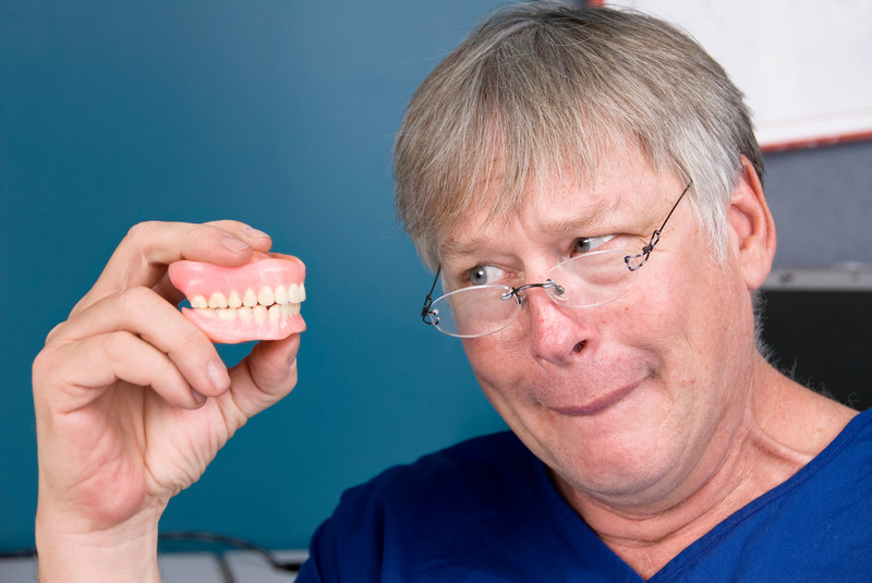 Patient looking at their old dentures